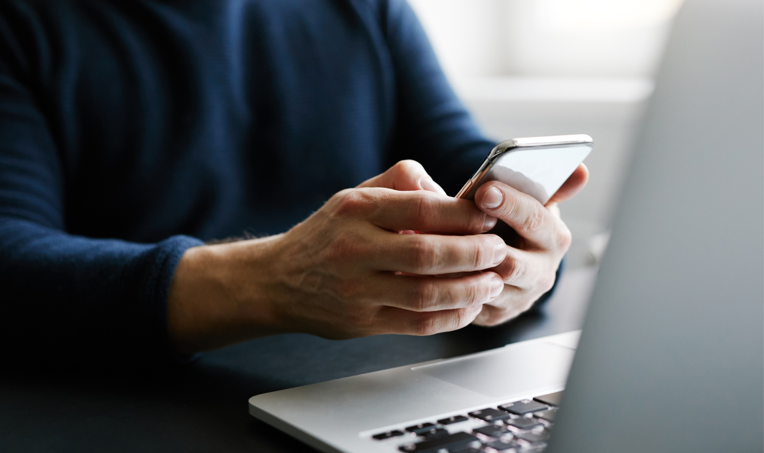 Man using mobile phone and laptop