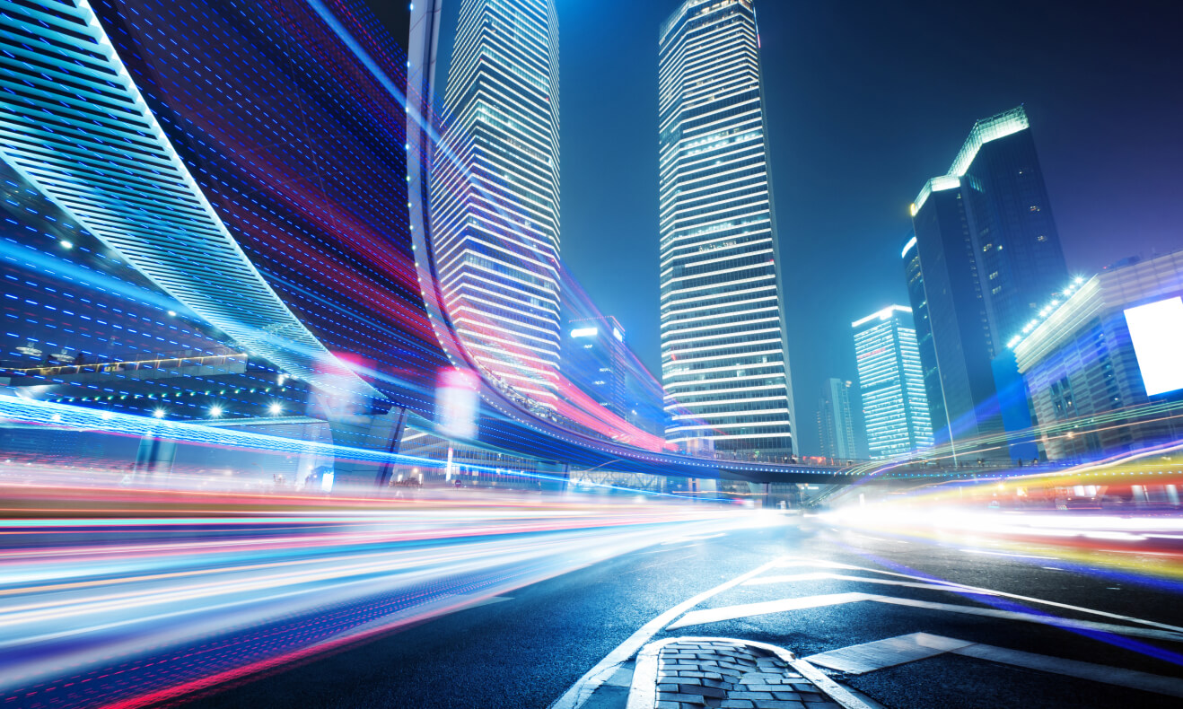 Bright light trails from vehicles moving on a busy highway at night in an urban setting